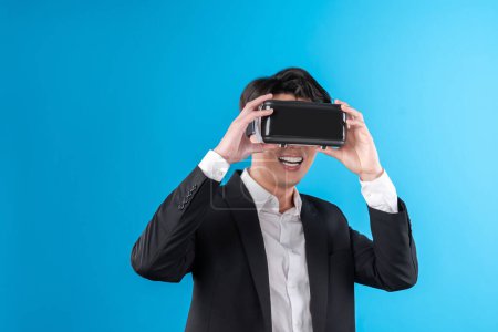 Téléchargez les photos : Sourire homme d'affaires asiatique à la recherche approfondie VR connexion au monde des affaires rapport dans métaverse futuriste, l'analyse des annonces de la technologie d'innovation dans la réalité virtuelle isolé copyspace bleu. Contrivance. - en image libre de droit