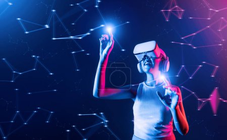 Photo for Female standing in cyberpunk neon light wear white VR headset and tank top connecting metaverse, future cyberspace community technology, She use two finger touch virtual reality object. Hallucination. - Royalty Free Image