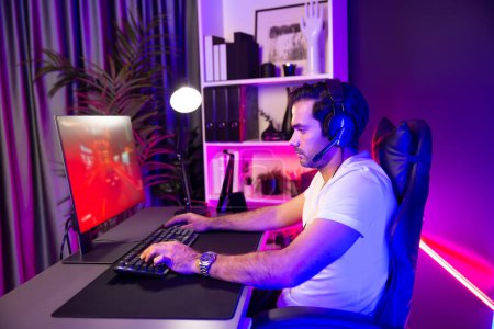 Photo for Wearing headphones smart gaming streamer enjoy playing car racing online game on pc screen to be champion with final competition in lifestyles on weekend at neon digital cyber lighting room. Surmise. - Royalty Free Image