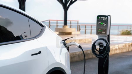 Batterie de recharge de voiture électrique à la station de recharge extérieure EV pour le voyage sur la route ou en voiture voyageant par le paysage marin, technologie d'énergie alternative et durable pour voiture écologique. Perpétuel