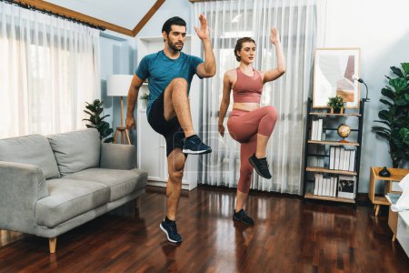 Athletic and sporty fitness couple or exercise buddy running posture at home body workout exercise session for fit physique and healthy sport lifestyle at home. Gaiety home exercise workout training.