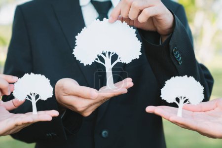 Photo for Group of business people holding white paper tree showcase environmental protection nurturing with nature, reduce CO2 and green house gases emission with reforestation for greener future. Gyre - Royalty Free Image