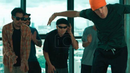 Gruppe multikultureller Hipster übt Breakdance mit Stadtbild oder Wolkenkratzer-Blick. Attraktive Menschen tanzen zusammen, während sie ihren Körper zur Musik bewegen. Outdoor-Sport 2024. Blauer Filter. Vorfreude.