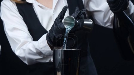 Makrographie von qualifizierten Barkeeper Hand messen Sirup und gießen Sie es in Shaker. Nahaufnahme des Prozesses, die die Geschicklichkeit und die Liebe zum Detail bei der Herstellung des perfekten Cocktails hervorhebt. Komestibel.