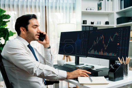 Trader businessman calling to consultant or partner with two stock exchange investment, compare data analysis to invest high profit value dynamic financial technology stock market at office. Surmise.